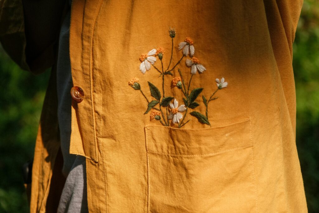 Close-up of a yellow jacket featuring delicate floral embroidery on a sunny day in Vietnam.